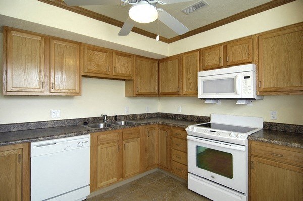 a kitchen with white appliances and wooden cabinets