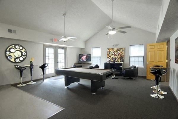 a living room with a pool table and a tv