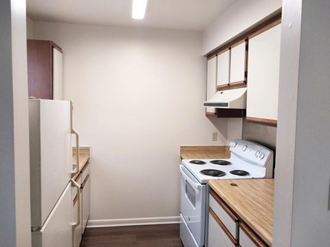 A small kitchen with a white stove and refrigerator.