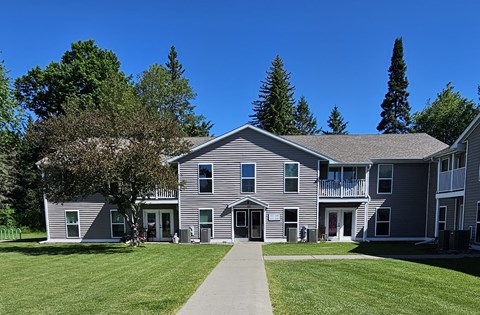 A grey building with a walkway in front of it.