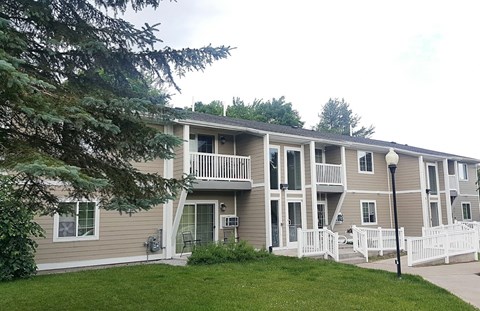 an apartment building with a yard and stairs
