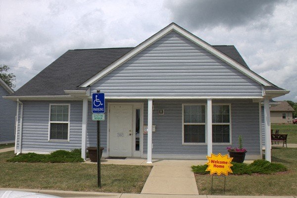 a blue house with a handicapped sign in front of it