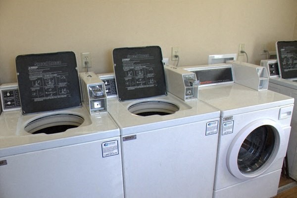 a laundromat with four washing machines and a washing machine and a dryer