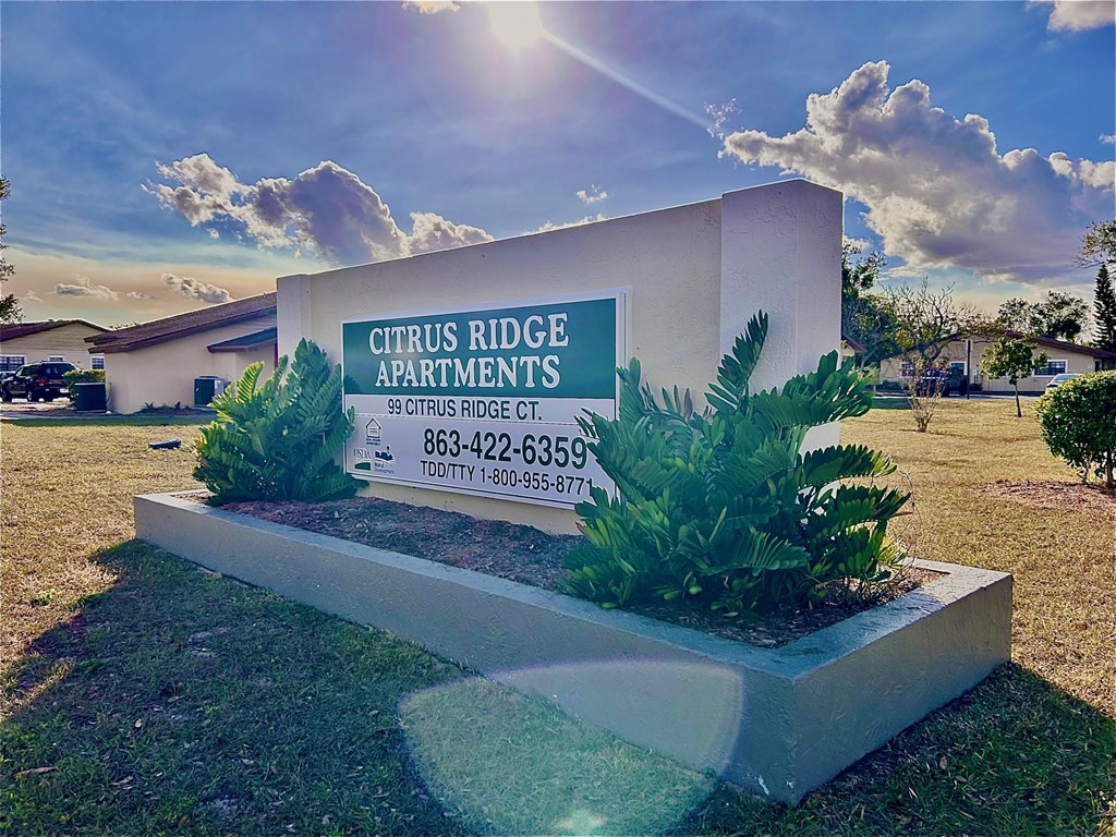 A sign for Citrus Ridge Apartments with a phone number and address.