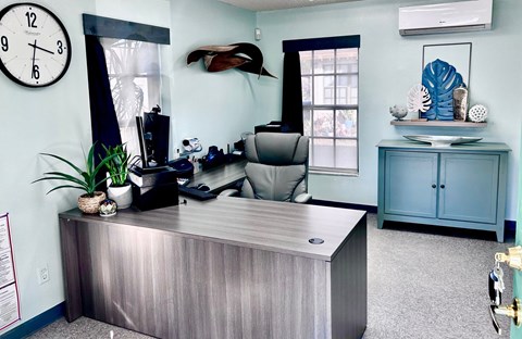 A reception desk with a clock on the wall above it.