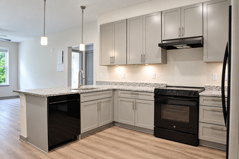 A kitchen with a black oven and a white counter.