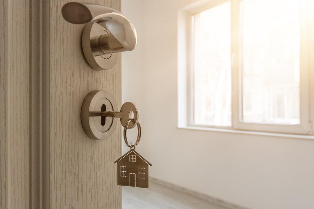 a door knob with a house shaped keychain on the door