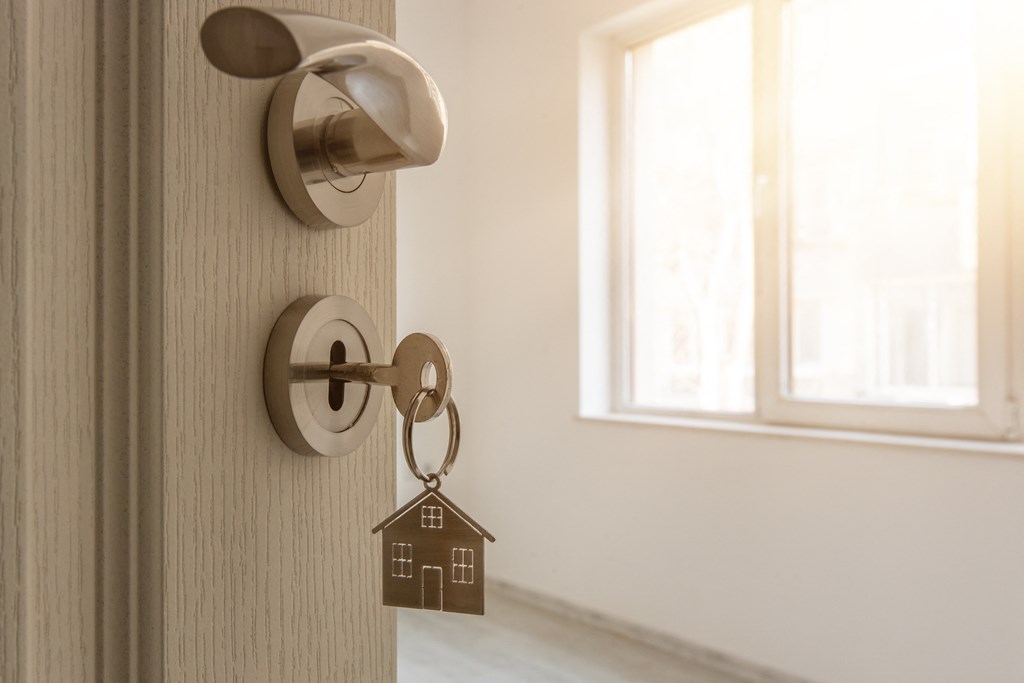 a door knob with a house shaped keychain on the door