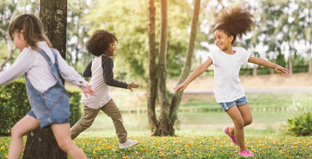 a group of young girls running in a park