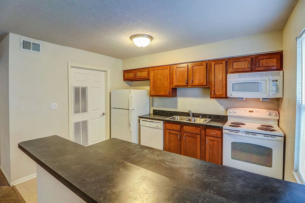 a kitchen with white appliances and wooden cabinets