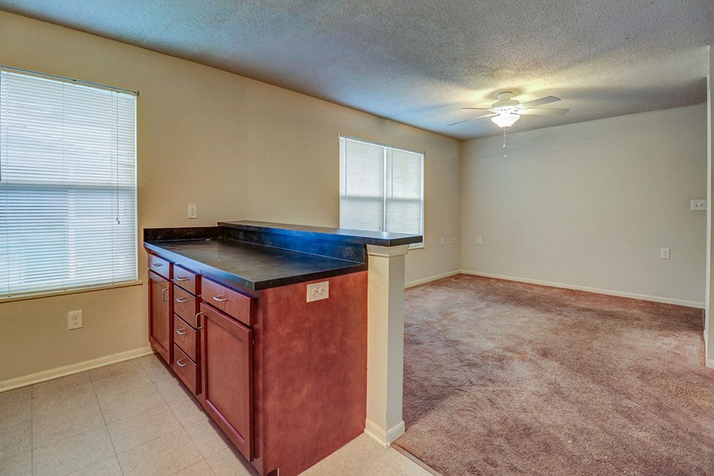 an empty living room with a counter top in the middle