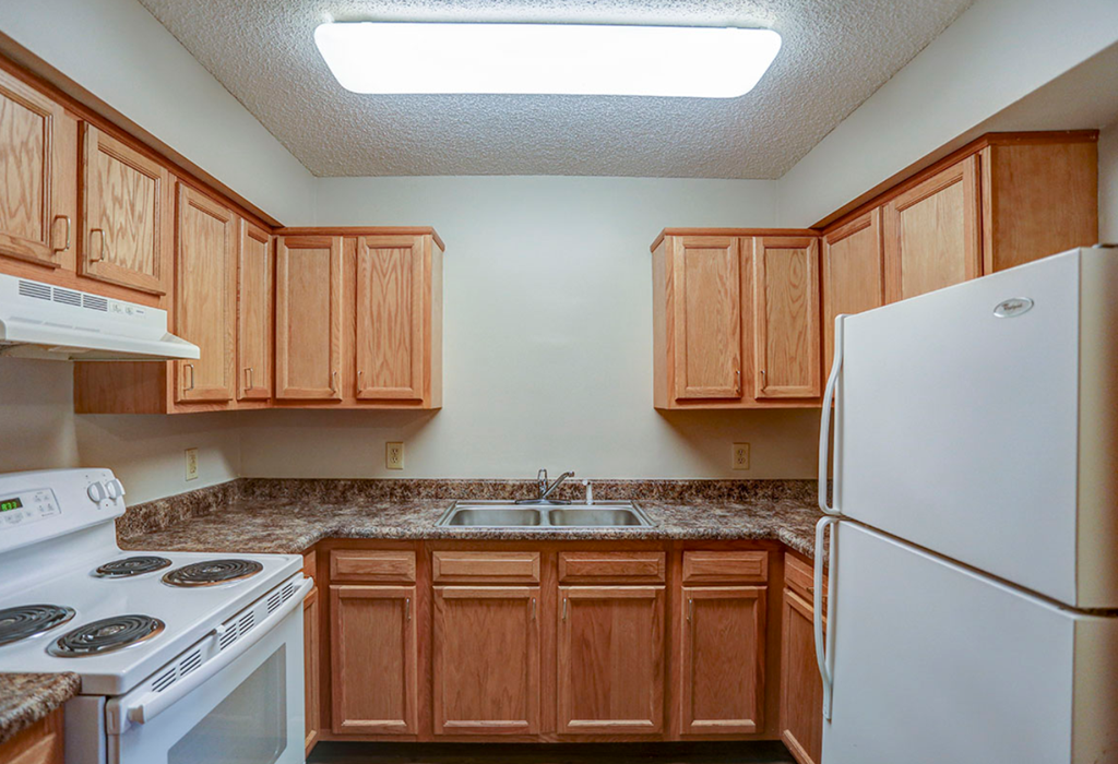 a kitchen with white appliances and wooden cabinets