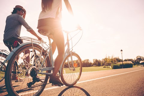 a man and a woman riding a bike down a road