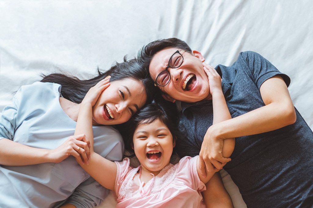 a woman and two children laying on a bed