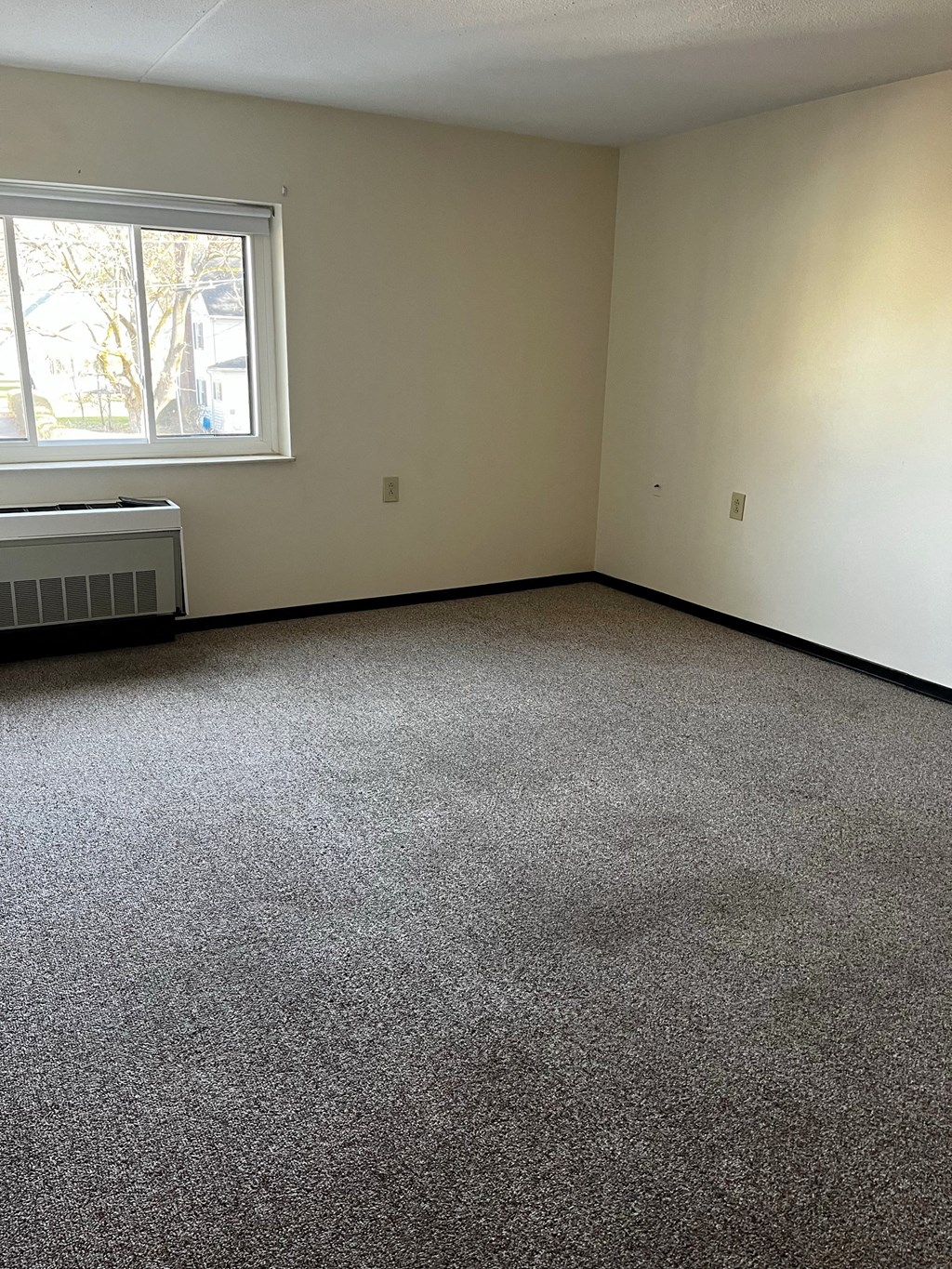 an empty room with carpet and a window