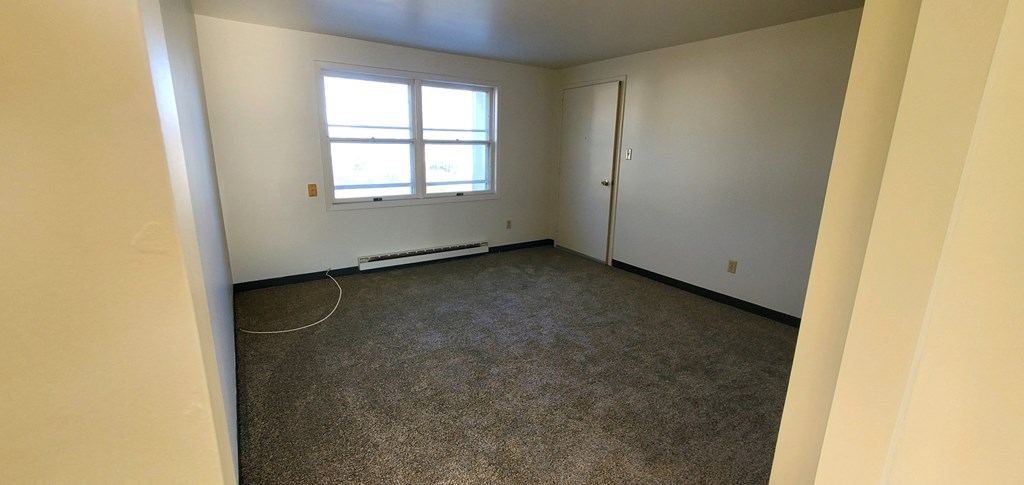 an empty room with a window and a door