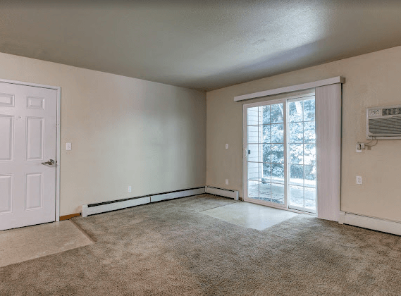 an empty living room with a door to a patio