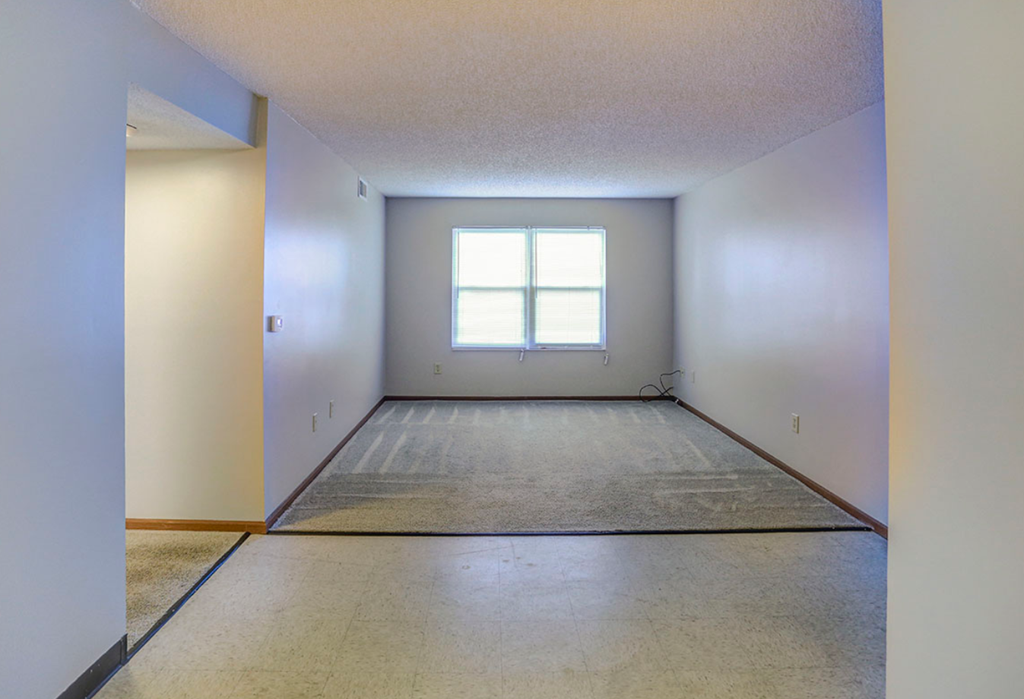 the living room of an empty house with a window