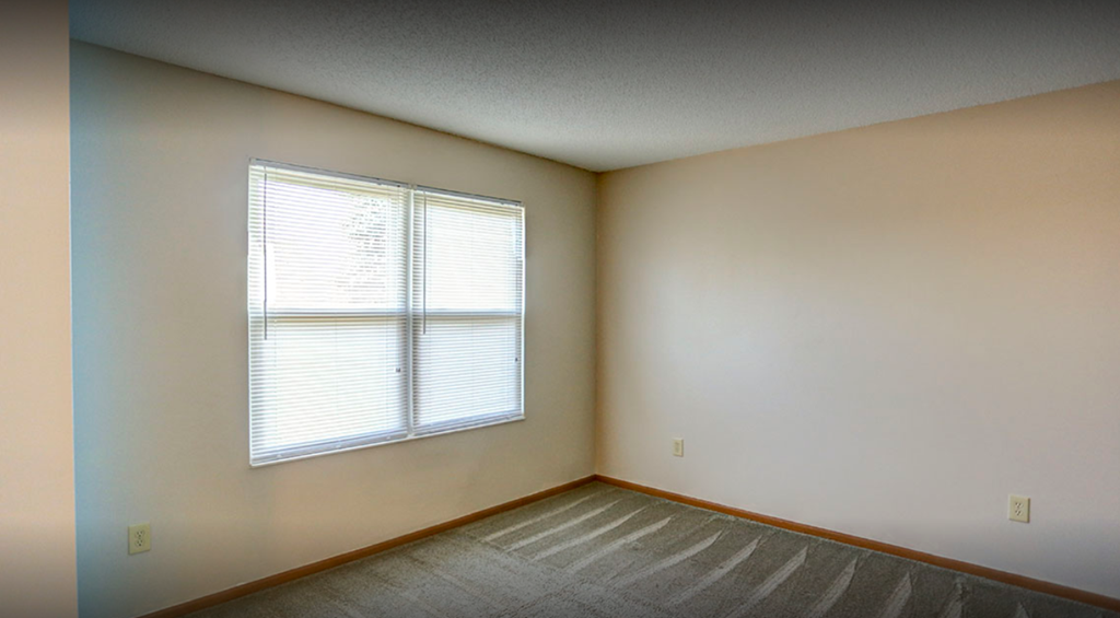 the living room of an empty house with a window