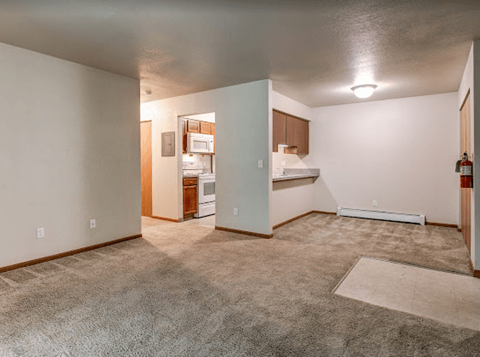 an empty living room with a kitchen in it