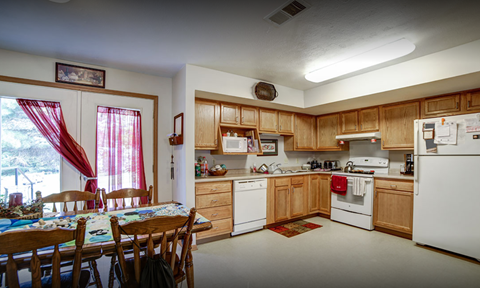 A kitchen with wooden cabinets and a white refrigerator.