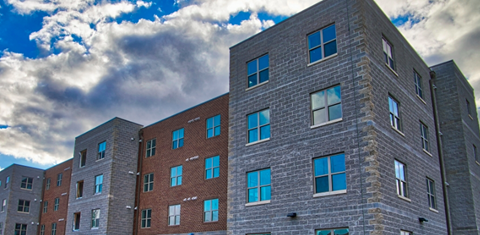 A large building with many windows and a grey stone exterior.