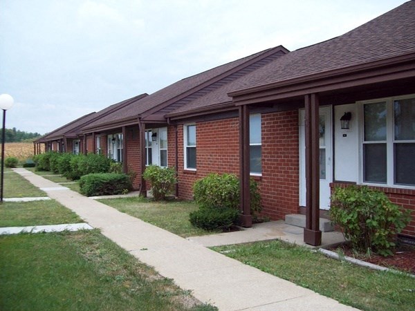 a row of brick houses with a sidewalk and grass