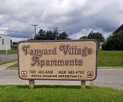 a sign in the grass that says taylor village apartments