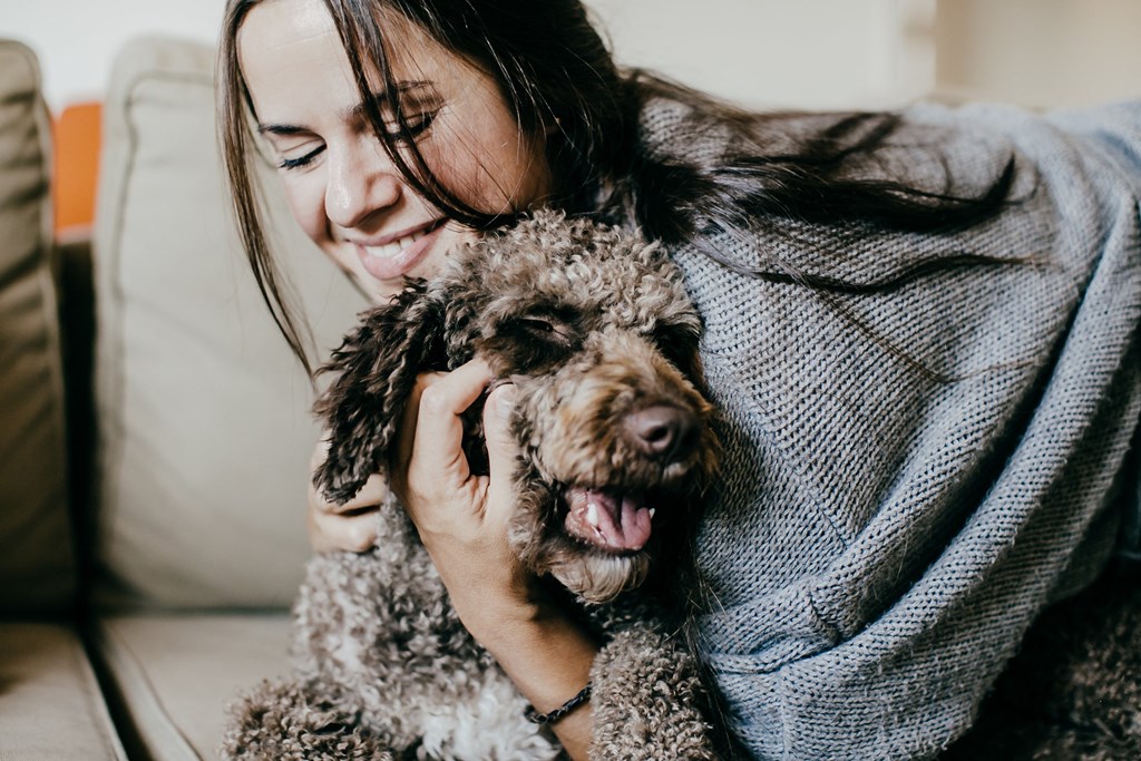 a woman holding a dog on a couch