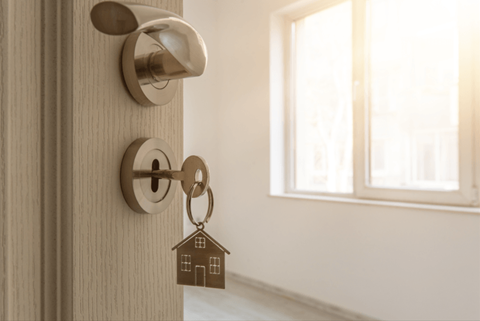 a door with a house keychain on the door knob