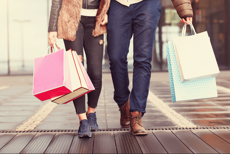 a man and woman walking with shopping bags