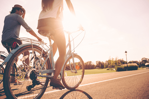 a man and a woman riding a bike down a street