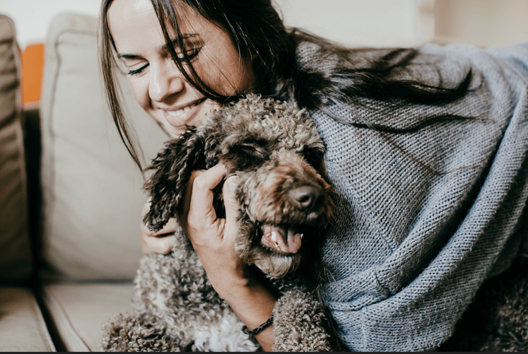 a woman sitting on a couch with a dog