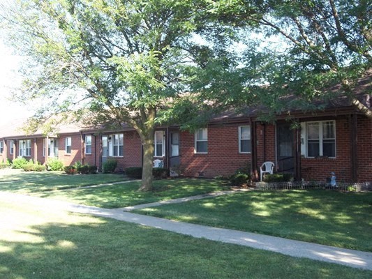 a red brick house with a sidewalk in front of it