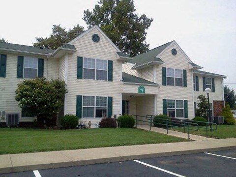 a white house with green shutters and a lawn