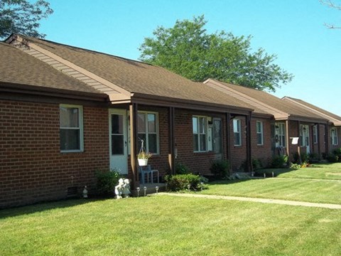 a brick house with a dog in the yard