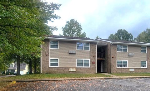 Apartment building with a grey facade and a balcony on the second floor.