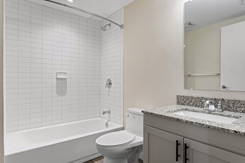A white bathroom with a toilet, sink, and bathtub.