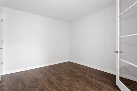 A room with white walls and a wooden floor.