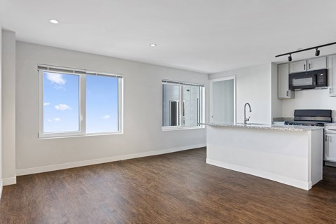 A spacious kitchen with a bar counter and a window.