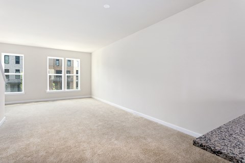 a bedroom with white walls and carpet and a window