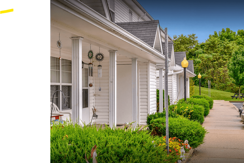 a row of white houses with a sidewalk in front of them