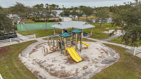 A playground with a yellow slide and a green roofed pavilion.