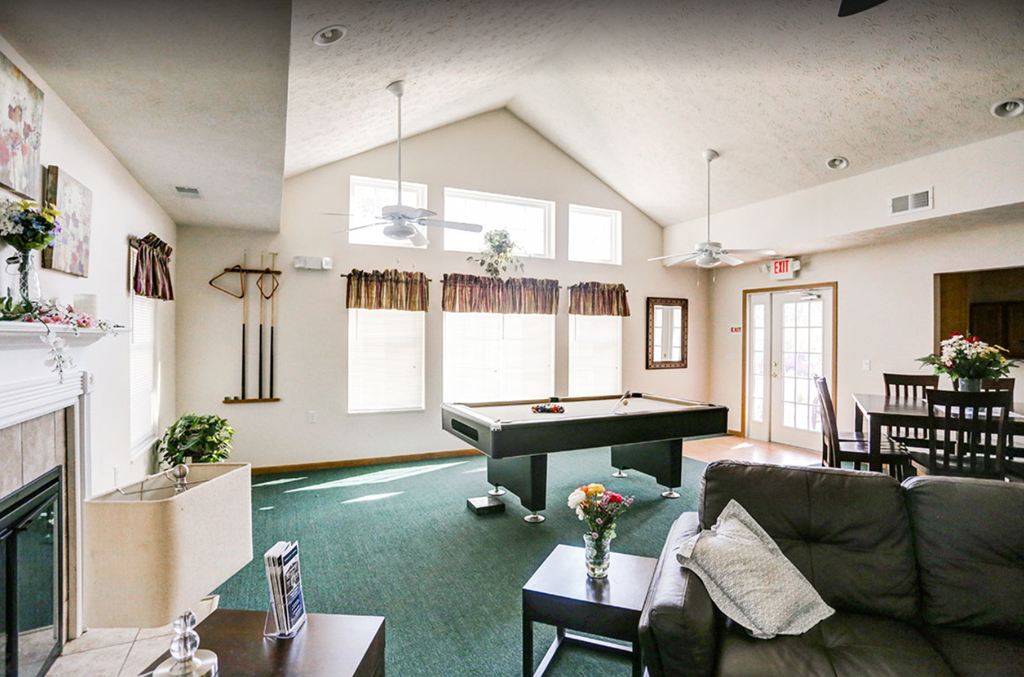 a living room with a pool table in the middle