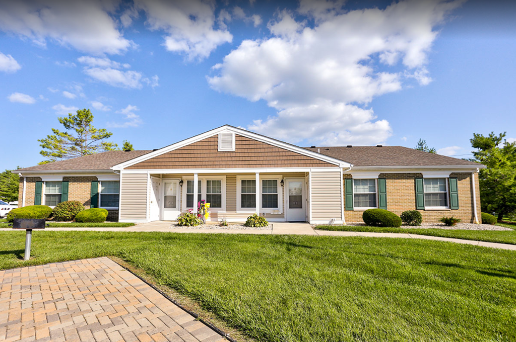 a house with a lawn and a walkway in front of it