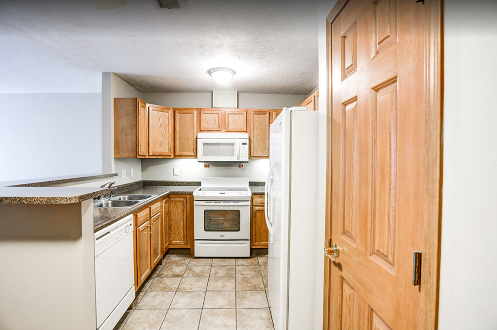 a kitchen with wooden cabinets and white appliances