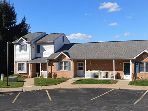 a brick and with a porch and a gray roof