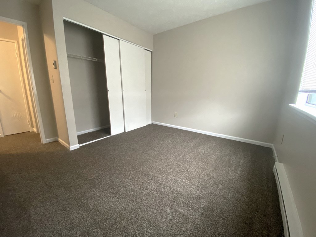 a bedroom with gray carpet and a closet