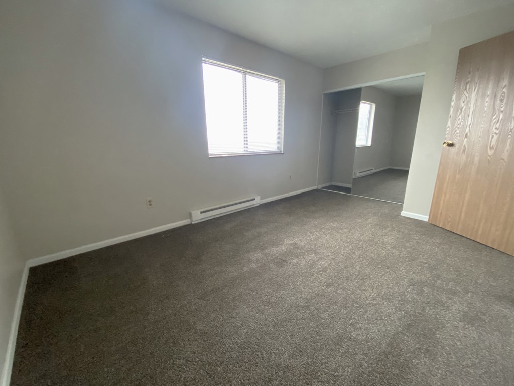 an empty room with a door and a window