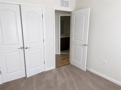 A white door is open to a dark room.